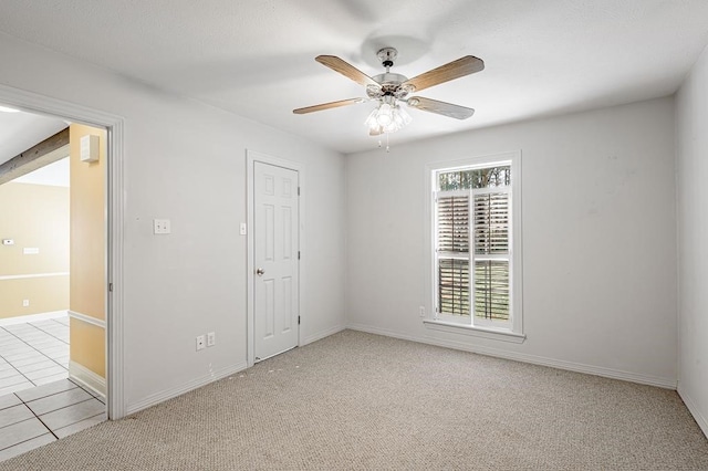 empty room featuring ceiling fan and light colored carpet