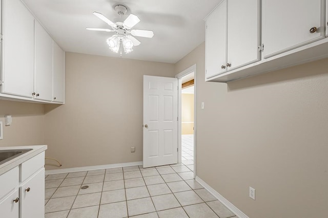 laundry area with ceiling fan and light tile patterned floors