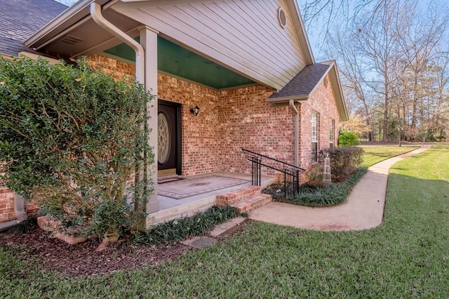 view of exterior entry featuring a yard