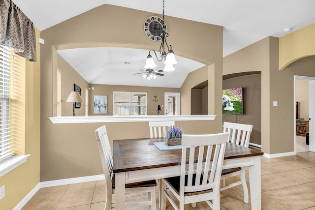 dining area with a notable chandelier, light tile patterned flooring, and lofted ceiling