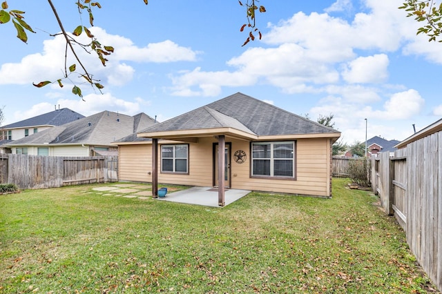 rear view of house with a patio and a lawn