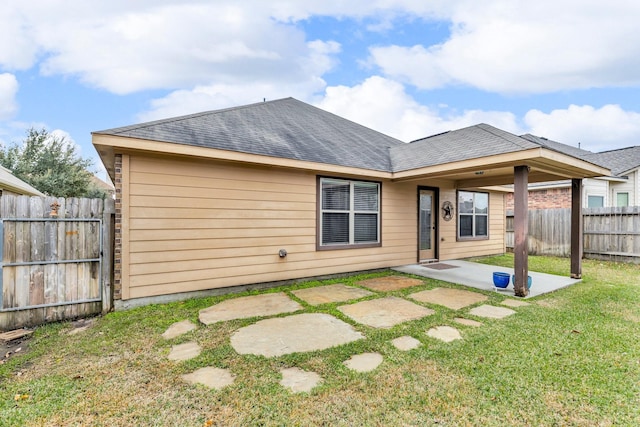 rear view of house featuring a lawn and a patio area