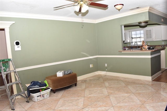 interior space with ceiling fan, sink, light tile patterned floors, and crown molding