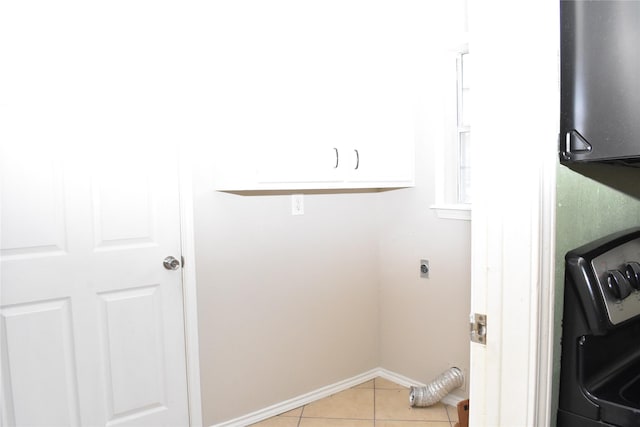 laundry area with hookup for an electric dryer and light tile patterned floors