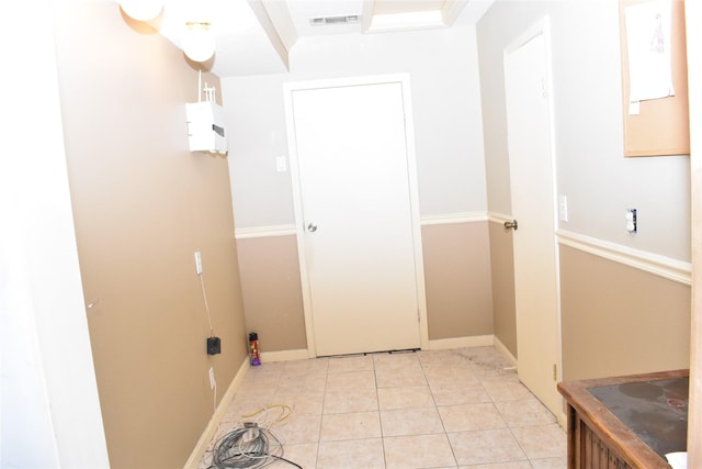 laundry area with light tile patterned floors