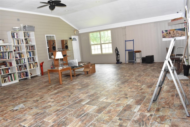 living area featuring vaulted ceiling, ceiling fan, and wooden walls