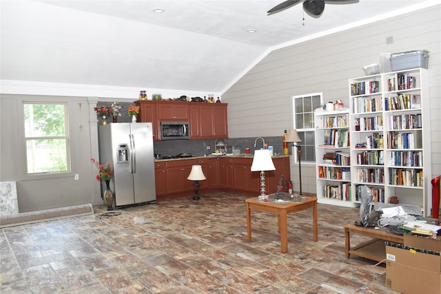 kitchen featuring decorative backsplash, stainless steel appliances, vaulted ceiling, and ceiling fan