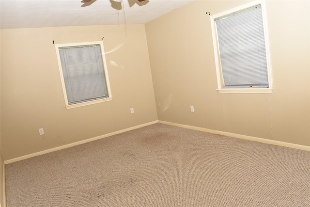 carpeted empty room featuring ceiling fan and vaulted ceiling