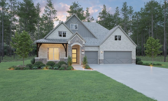 view of front of property featuring a garage and a lawn