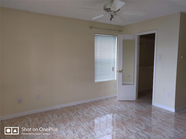 unfurnished room with ceiling fan and a textured ceiling