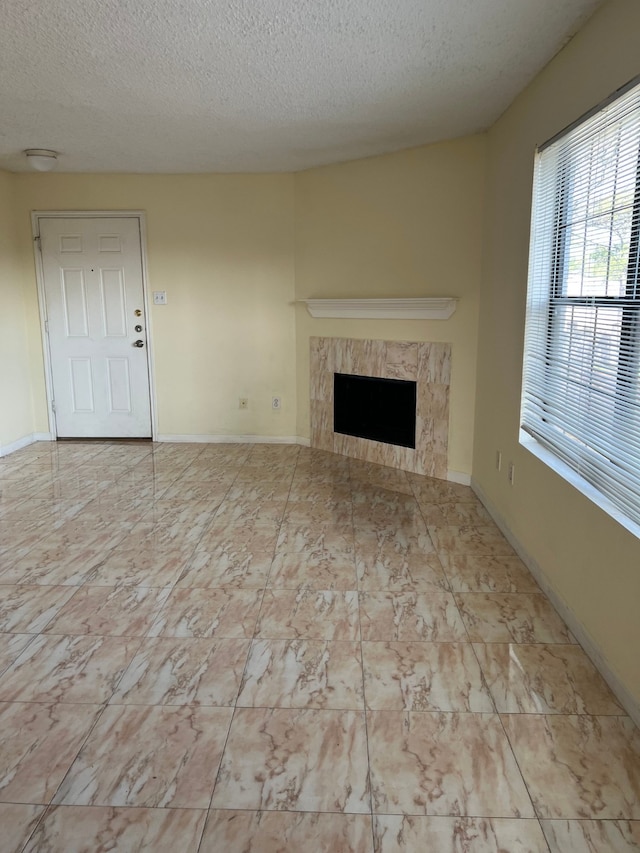 unfurnished living room with a textured ceiling and a fireplace