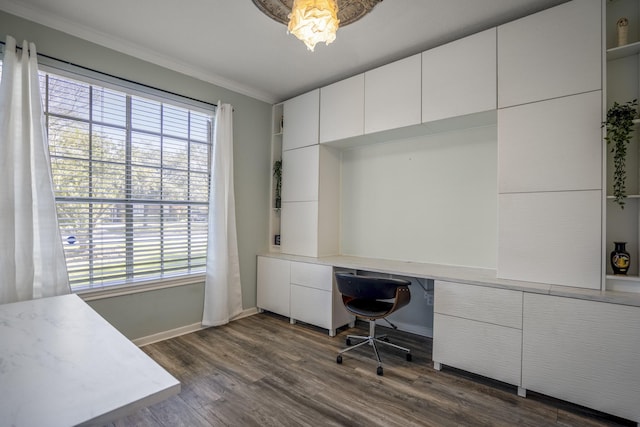 office area featuring built in desk, dark wood-type flooring, a wealth of natural light, and ornamental molding