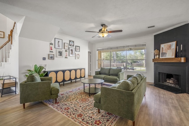 living room featuring a fireplace, a textured ceiling, hardwood / wood-style flooring, and ceiling fan