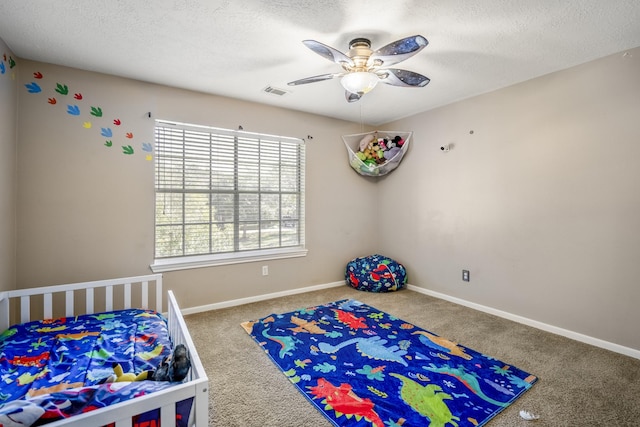 bedroom featuring ceiling fan, carpet, and a textured ceiling