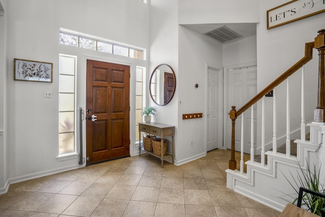 tiled foyer with plenty of natural light and a towering ceiling