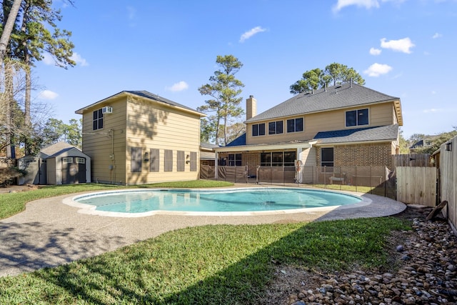 view of swimming pool with a lawn, a patio, and a storage unit