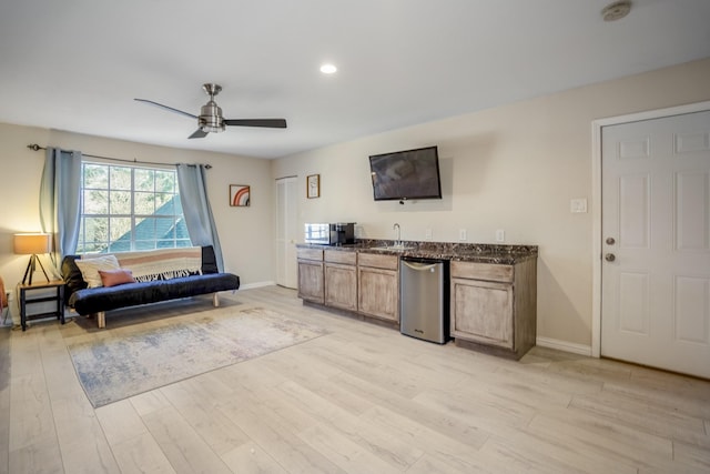 living room featuring light wood-type flooring, ceiling fan, and sink