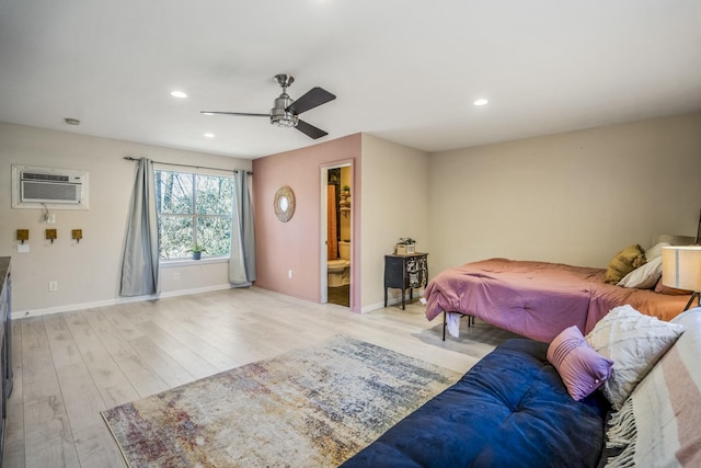 unfurnished bedroom with ceiling fan, light hardwood / wood-style floors, an AC wall unit, and ensuite bathroom