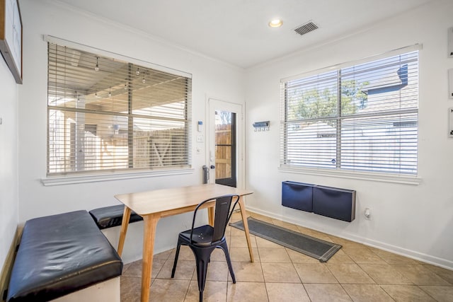 dining space with light tile patterned floors and crown molding