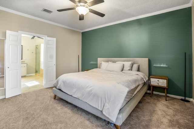 carpeted bedroom with a textured ceiling, ceiling fan, crown molding, and ensuite bath