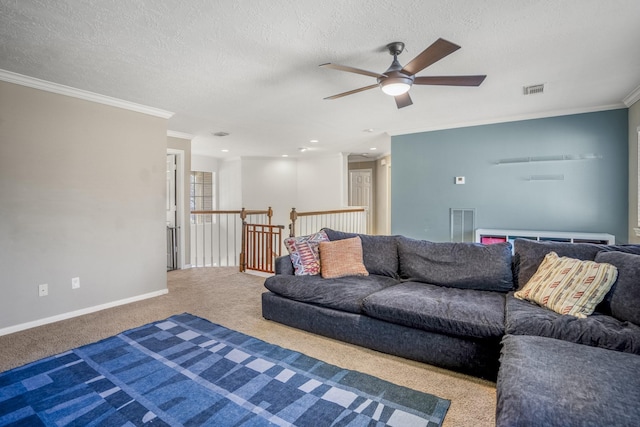 carpeted living room featuring ceiling fan, ornamental molding, and a textured ceiling