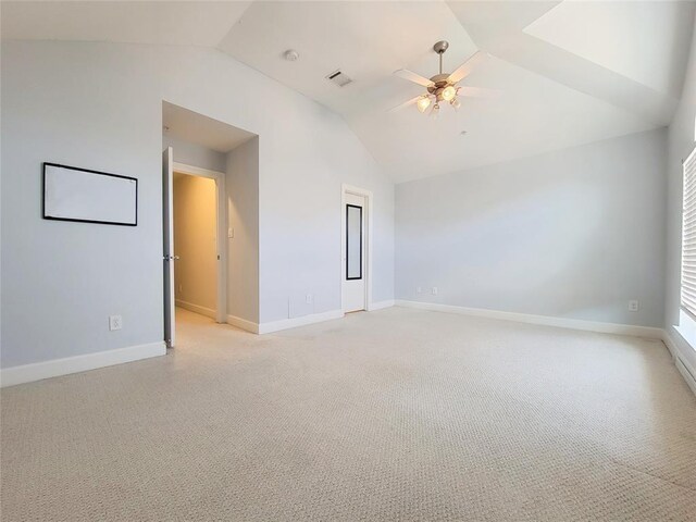 unfurnished room with ceiling fan, light colored carpet, and vaulted ceiling