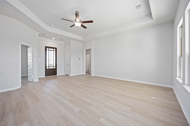 unfurnished living room featuring a raised ceiling, ceiling fan, and light wood-type flooring