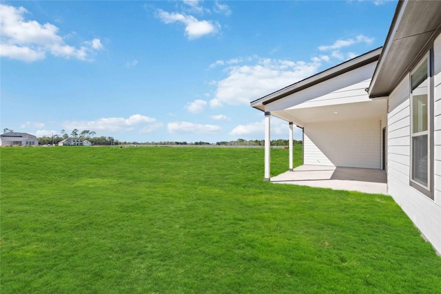 view of yard with a rural view and a patio