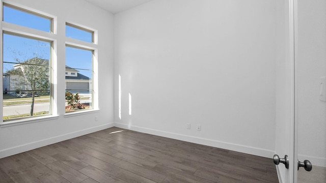 empty room with dark hardwood / wood-style flooring