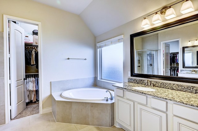 bathroom featuring tile patterned floors, vanity, separate shower and tub, and lofted ceiling