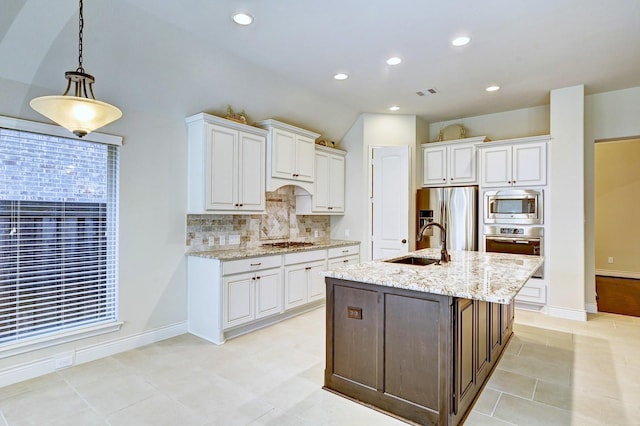 kitchen with white cabinetry, sink, hanging light fixtures, light stone counters, and appliances with stainless steel finishes