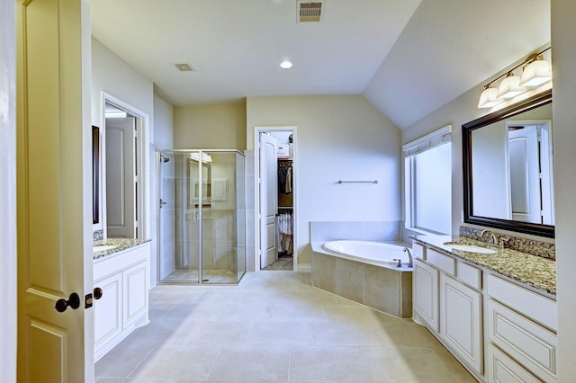 bathroom featuring tile patterned flooring, shower with separate bathtub, vanity, and lofted ceiling