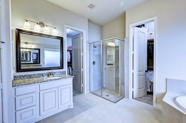 bathroom with tile patterned flooring, vanity, and separate shower and tub