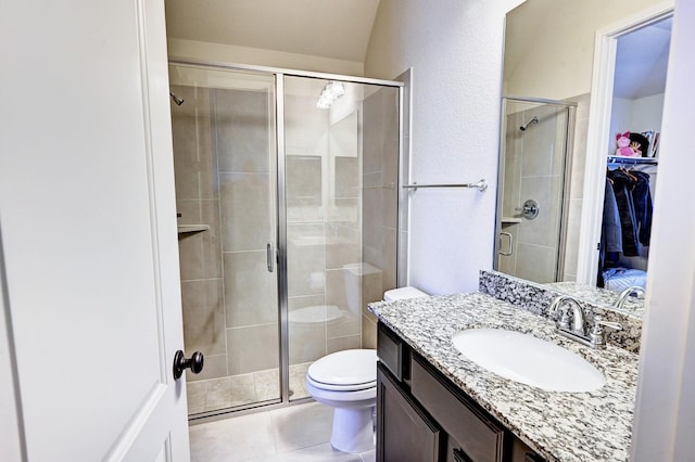 bathroom with tile patterned flooring, vanity, toilet, and an enclosed shower