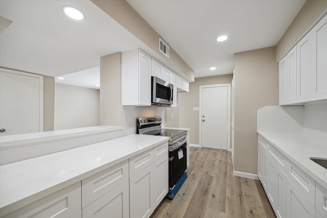 kitchen featuring white cabinetry, light hardwood / wood-style flooring, and black range with electric cooktop