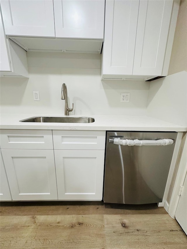 kitchen featuring dishwasher, white cabinets, light hardwood / wood-style floors, and sink