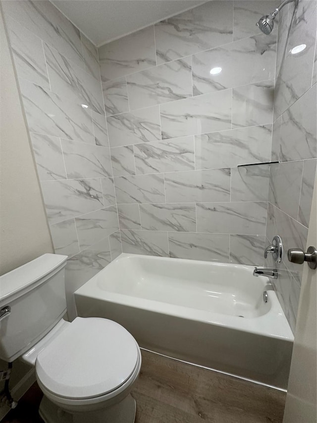 bathroom featuring bathtub / shower combination, wood-type flooring, and toilet