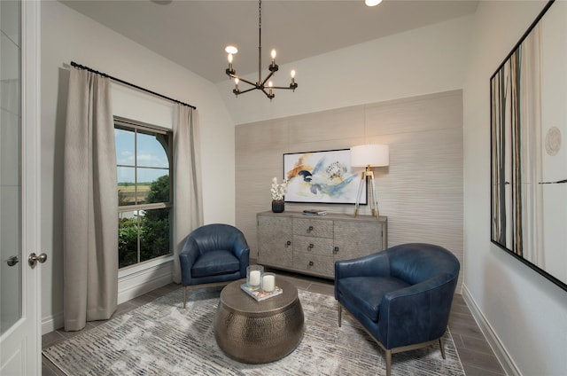 sitting room featuring vaulted ceiling and an inviting chandelier