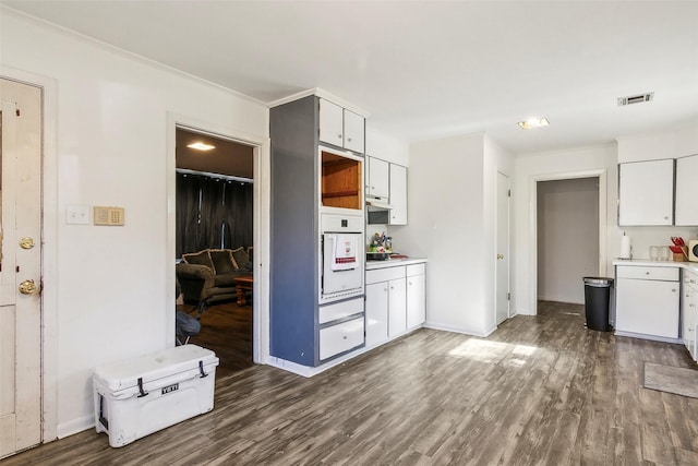 kitchen featuring white cabinets, dark hardwood / wood-style flooring, and oven