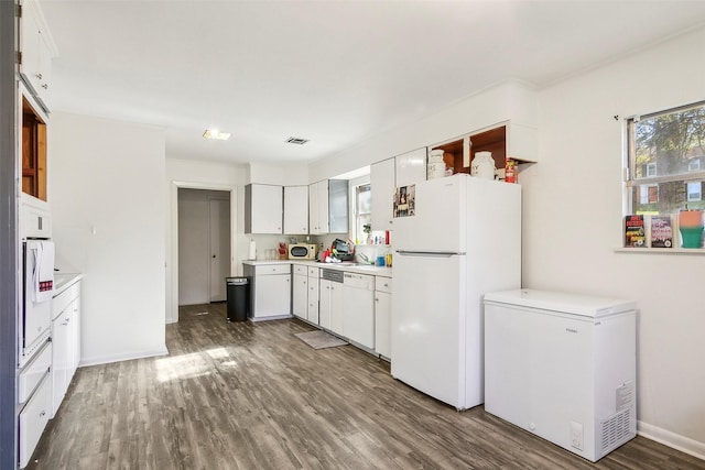 kitchen with white appliances, white cabinetry, and a wealth of natural light