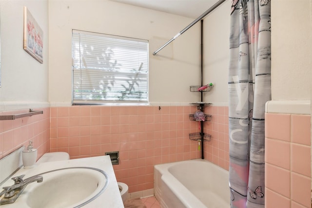 full bathroom featuring shower / bath combination with curtain, toilet, sink, and tile walls