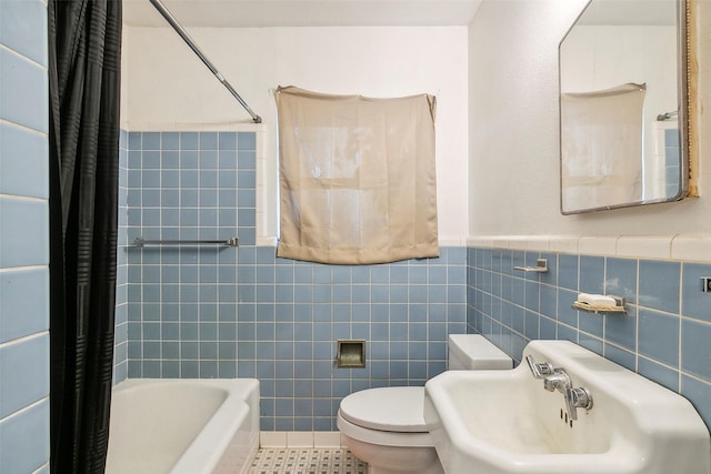 full bathroom with tile patterned floors, sink, toilet, shower / bath combo with shower curtain, and tile walls