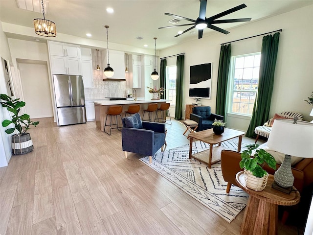 living room with light wood-style floors, visible vents, a ceiling fan, and recessed lighting