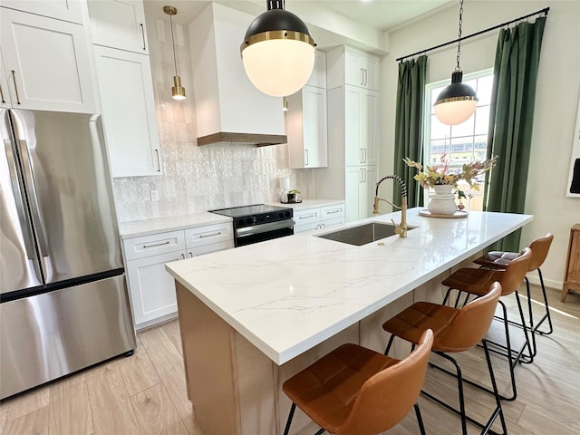 kitchen featuring backsplash, electric range, freestanding refrigerator, a sink, and wall chimney exhaust hood