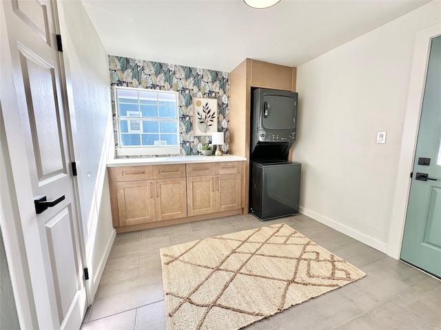 interior space with stacked washer / drying machine, light tile patterned flooring, and light brown cabinets