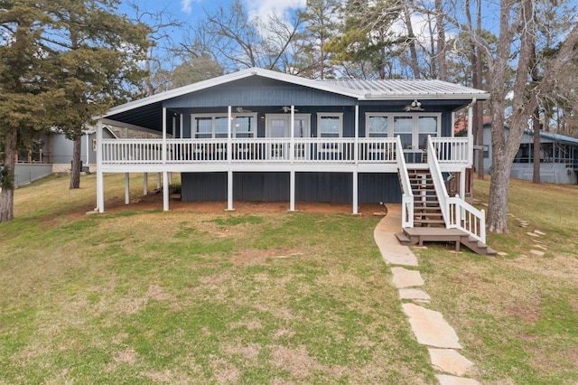 view of front of property with ceiling fan, a wooden deck, and a front yard