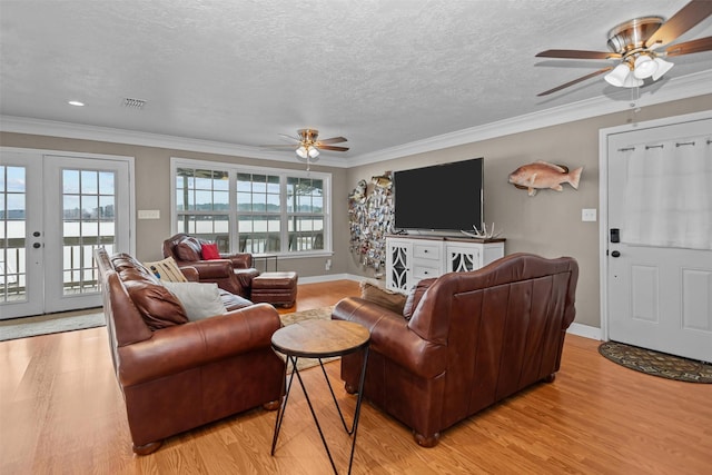 living room with french doors, crown molding, ceiling fan, a textured ceiling, and light hardwood / wood-style floors