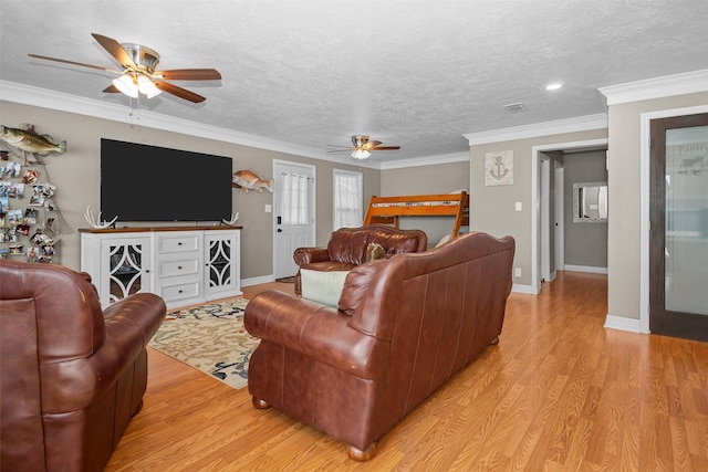 living room with ceiling fan, light hardwood / wood-style floors, a textured ceiling, and ornamental molding