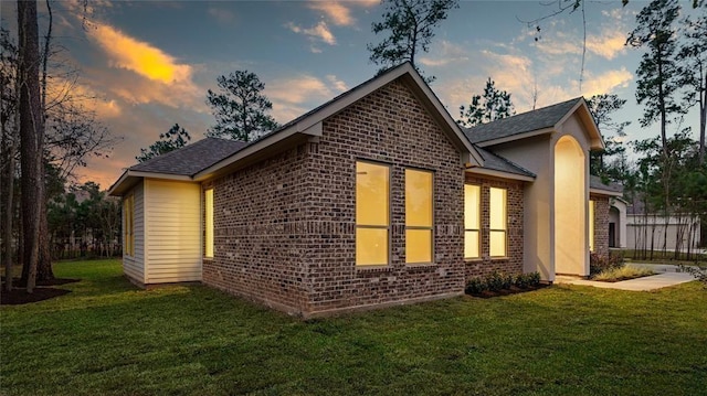 property exterior at dusk with a yard