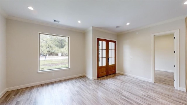 empty room with french doors, crown molding, and light hardwood / wood-style flooring